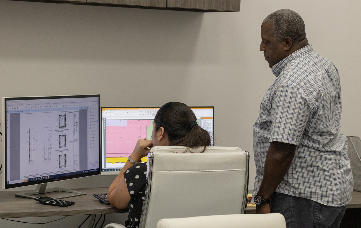 A man and a woman looking at blueprints